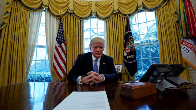U.S. President Donald Trump sits at his desk during an interview with Reuters 