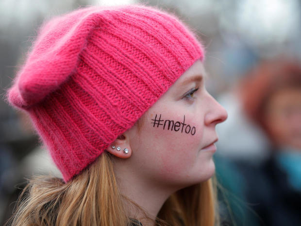 Caitlyn MacGregor, with "#metoo" written on her face and wearing a pink "pussyhat", attends the second annual Women's March in Cambridge 