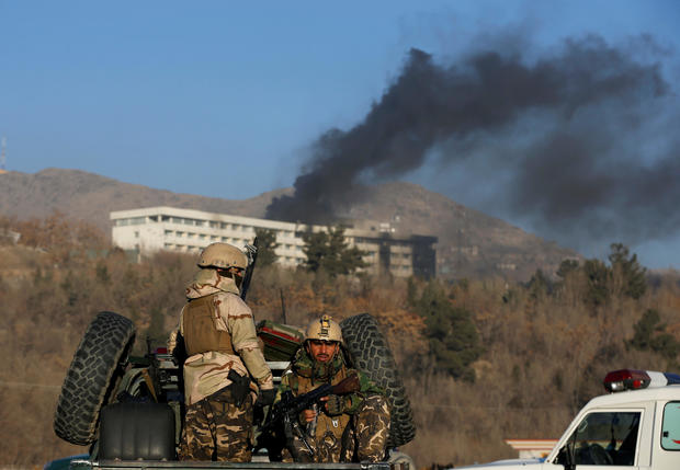 Afghan security forces keep watch as smoke rises from the Intercontinental Hotel in Kabul,ÊAfghanistan 