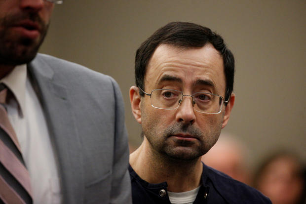 Larry Nassar, a former team USA Gymnastics doctor who pleaded guilty in November 2017 to sexual assault charges, stands with his legal team during his sentencing hearing in Lansing 