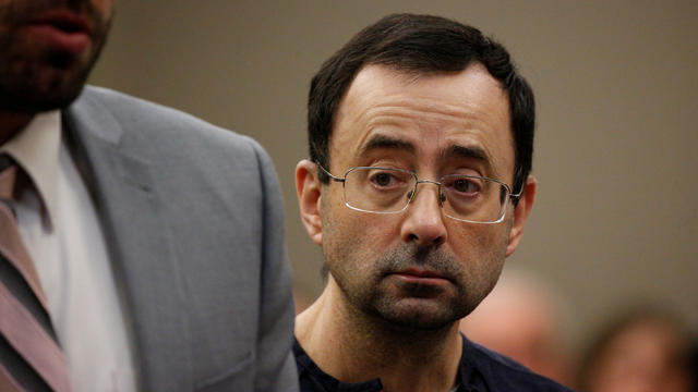 Larry Nassar, a former team USA Gymnastics doctor who pleaded guilty in November 2017 to sexual assault charges, stands with his legal team during his sentencing hearing in Lansing 