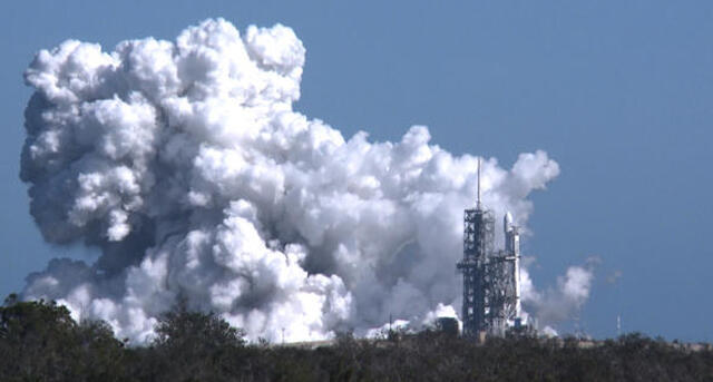 A towering exhaust plume billows into the afternoon sky during a test-firing of the 27 engines making up the three core-stage boosters in SpaceX's new Falcon Heavy rocket at the Kennedy Space Center in Florida on Jan. 24, 2018. 