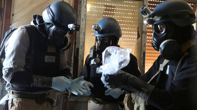 FILE PHOTO: U.N. chemical weapons expert holds a plastic bag containing samples from one of the sites of an alleged chemical weapons attack in Ain Tarma, Damascus 