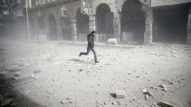 A man is seen running after an air raid in the besieged town of Douma in eastern Ghouta in Damascus 