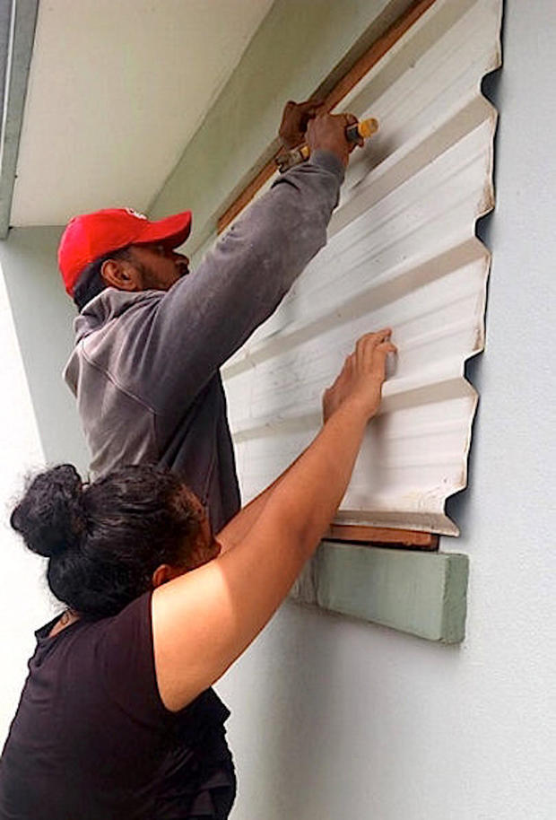 A supplied image shows locals covering windows to office buildings as part of preparations for Cyclone Gita in the Tonga capital of Nuku'alofa 