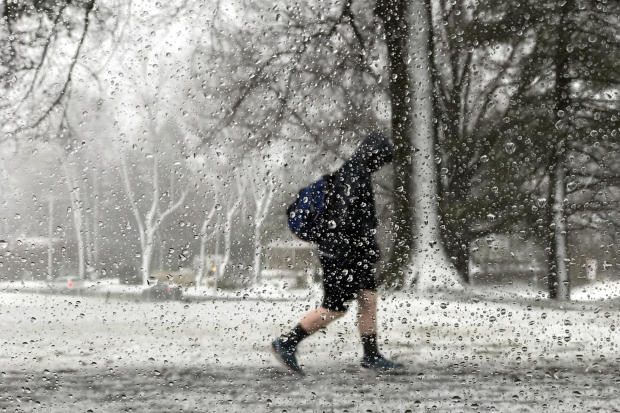 A student walks out of school during a storm in Newtown, Pennsylvania, March 2, 2018. 
