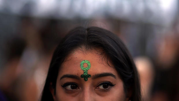 A woman has the symbol for women painted on her face during a demonstration on International Women's Day in Buenos Aires 