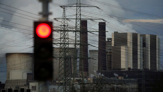 A traffic light signals red in front of the Weisweiler brown coal power plant of German energy supplier RWE 