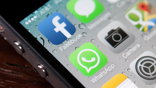 Facebook WhatsApp icons displayed on iPhone mobile phone screen 