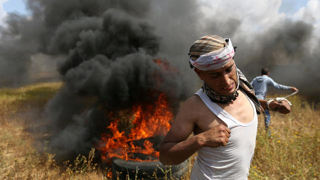 Palestinian runs during clashes with Israeli troops, during a tent city protest along the Israel border with Gaza, demanding the right to return to their homeland, the southern Gaza Strip 