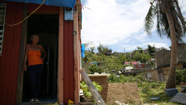 Bexaida Torres stands in the door of what is left of her home after Hurricane Maria hit the island in September, in a neighborhood in Canovanas, Puerto Rico, April 10, 2018. 