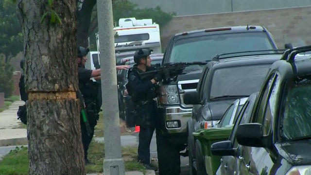 Officers watch a house in Los Angeles where a gunman was in a standoff with police on April 24, 2018. 