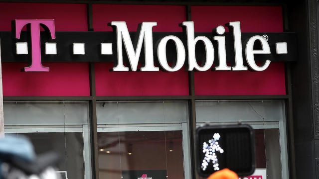 FILE PHOTO: A smartphones with Sprint logo are seen in front of a screen projection of T-mobile logo, in this picture illustration 