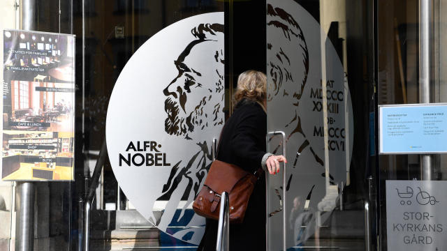 A woman opens the door of the Alfred Nobel Museum in Stockholm, Sweden, that is located in the building where the winner of the 2017 Nobel Prize in literature was announced on Oct. 5, 2017. 