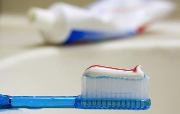 A toothbrush with toothpaste sits on a s 