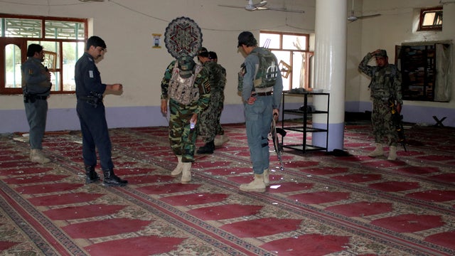 Afghan policemen inspect a mosque after a blast in Khost province 