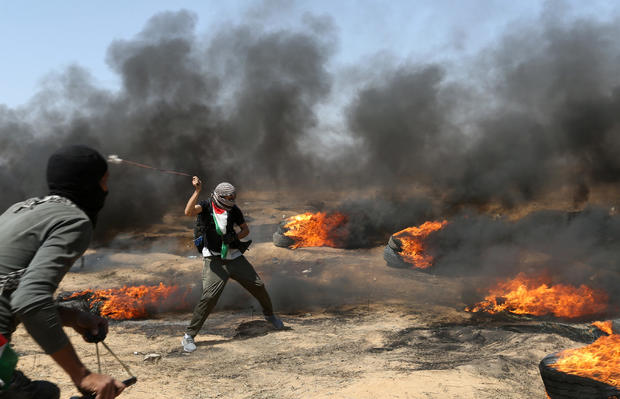 Demonstrator uses a sling to hurl stones at Israeli forces during a protest where Palestinians demand the right to return to their homeland, at the Israel-Gaza border in the southern Gaza Strip 