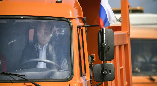 Russian President Vladimir Putin drives a Kamaz truck during a ceremony opening a bridge to connect the Russian mainland with the Crimean peninsula across the Kerch Strait, May 15, 2018. 