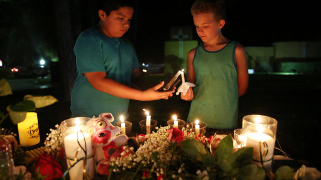 Attendees light a candle during a vigil for the victims of a shooting at Santa Fe High School that left several dead and injured in Santa Fe, Texas 