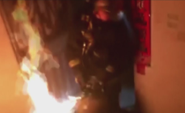 firefighter drags burning liquefied gas cylinder from a house 