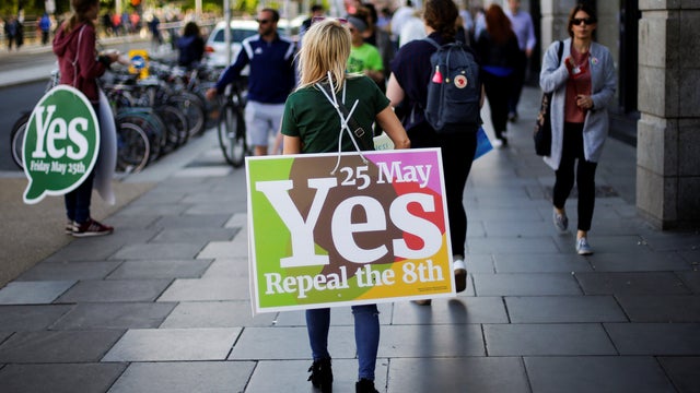 A woman carries a placard as Ireland holds a referendum on lliberalising abortion laws, in Dublin 