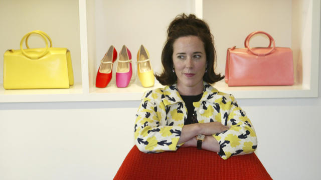 Designer Kate Spade poses among handbags and shoes from her collection in New York May 13, 2004. 