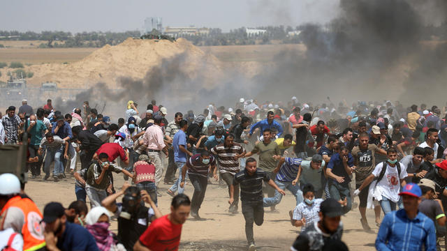 Palestinian demonstrators run for cover from Israeli gunfire during a protest marking al-Quds Day, (Jerusalem Day), at the Israel-Gaza border in the southern Gaza Strip 