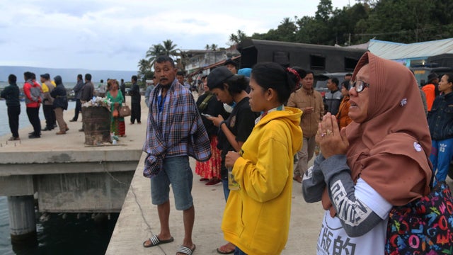 Local residents and relatives of missing passengers from a ferry accident on Lake Toba, wait on the dock at Tigaras Port in Simalungun 