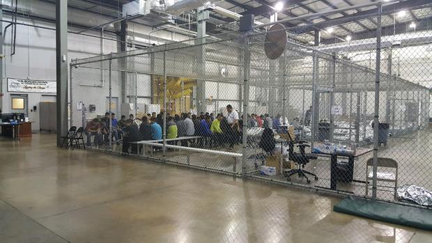 Inside Border Protection's processing detention center: Chain link fences and thermal blankets 