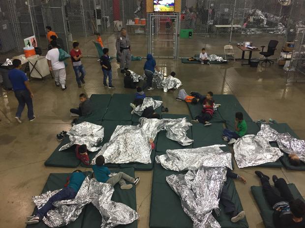 Inside Border Protection's processing detention center: Chain link fences and thermal blankets 