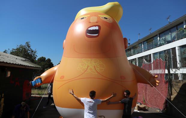 People inflate a helium filled Donald Trump blimp which they hope to deploy during The President of the United States' upcoming visit, in London 
