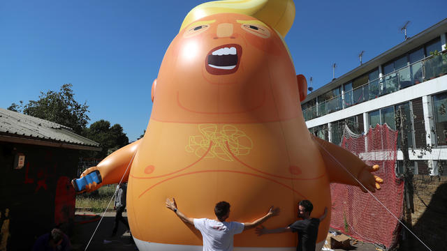 People inflate a helium filled Donald Trump blimp which they hope to deploy during The President of the United States' upcoming visit, in London 