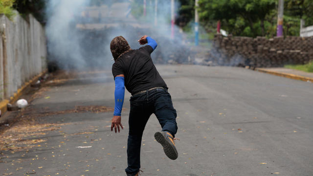 Demonstrator throws a homemade device during the funeral service of Jose Esteban Sevilla Medina, who died during clashes with pro-government supporters in Monimbo 