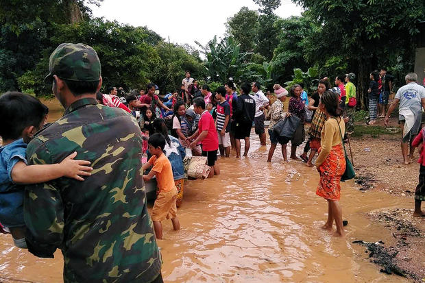 Villagers carry their belonging as they evacuate after the Xepian-Xe Nam Noy hydropower dam collapsed in Attapeu province 
