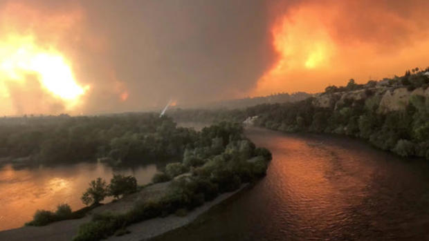 Smoke and flames are seen as a wildfire spreads through Redding, California 