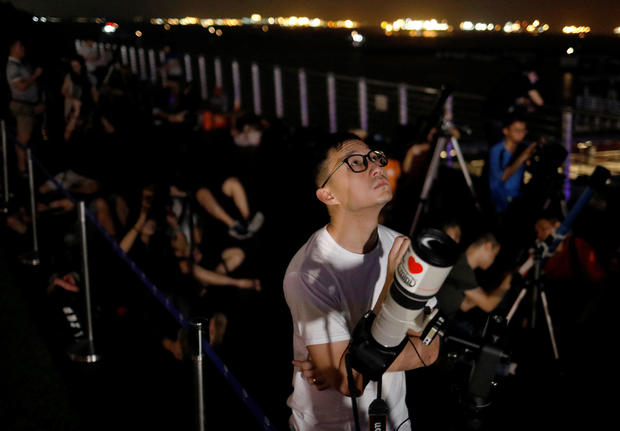 Astronomy enthusiasts wait to see the lunar eclipse of a blood moon at Marina South Pier in Singapore 