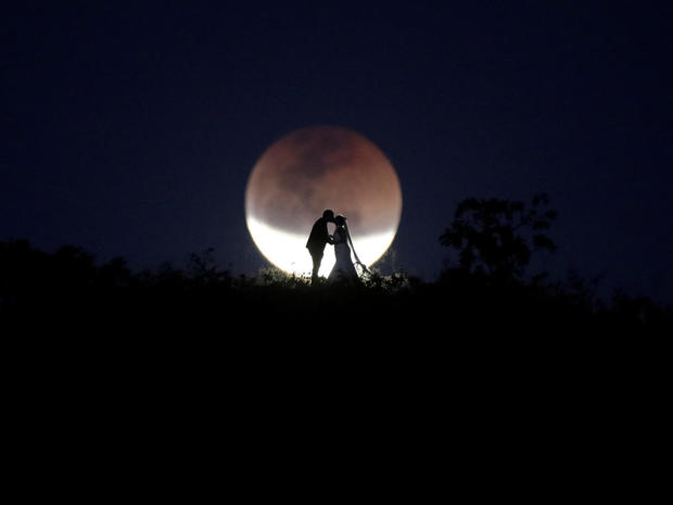 A couple poses for photo during a total lunar eclipse from in Brasilia 