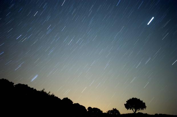 A meteor streaks across the sky against 