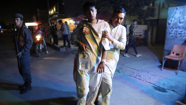 An injured boy is held up outside a hospital following a deadly attack in Kabul, Afghanistan, Sept. 5, 2018. 