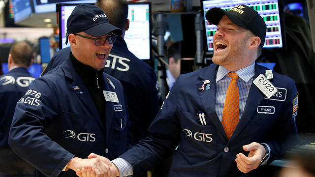 Traders celebrate on the main trading floor of the NYSE as the Dow Jones Industrial Average passes 20,000 after opening of trading session in New York 