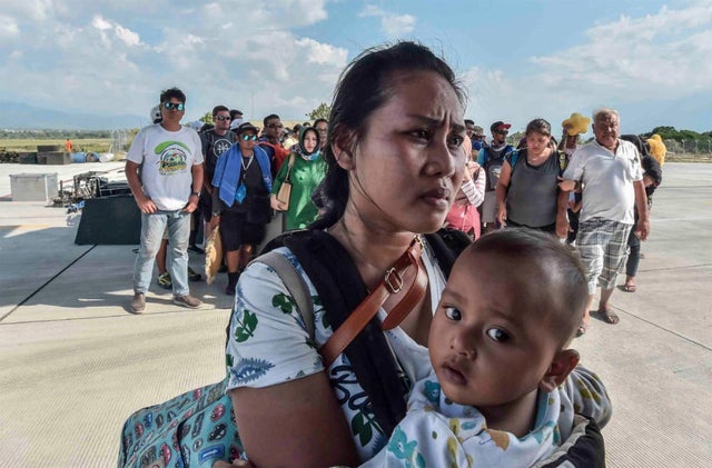 People injured or affected by the earthquake and tsunami wait to be evacuated on an air force plane in Palu, Central Sulawesi 