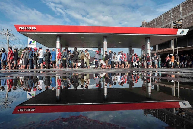 People queue for fuel at a petrol station in earthquake and tsunami hit Palu, Central Sulawesi 