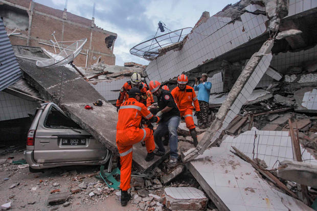 Search and rescue workers evacuate an earthquake and tsunami survivor trapped in a collapsed restaurant, in Palu, Central Sulawesi 