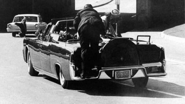 President John F. Kennedy slumps down in the back seat of the presidential limousine after he was fatally shot in Dallas on Nov. 22, 1963. Jacqueline Kennedy leans over the president as Secret Service agent Clinton Hill rides on the back of the car. 