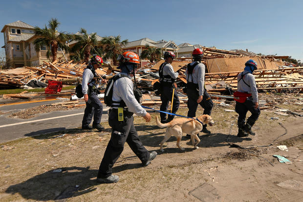 Search and rescue crews walk past damage caused by Hurricane Michael in Mexico Beach 