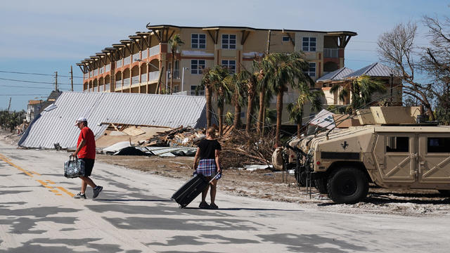 People carry suitcases after Hurricane Michael in Mexico Beach 