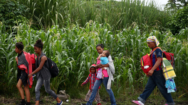 Honduran migrants, part of a caravan trying to reach the U.S., walk during a new leg of their travel in Siquinala 