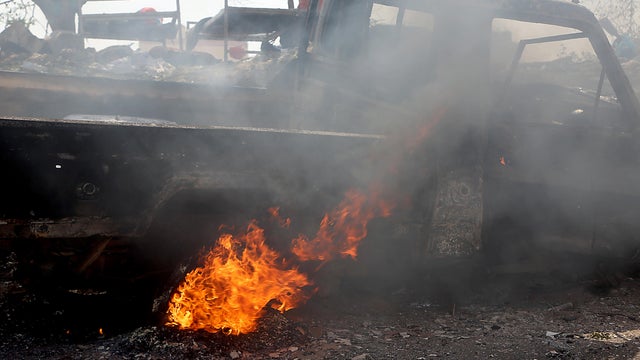 This picture taken on Oct. 24, 2018 shows fire near the wreckage of a car reportedly destroyed in an air strike in Yemen's Huthi-held Red Sea port of Hodeida. 