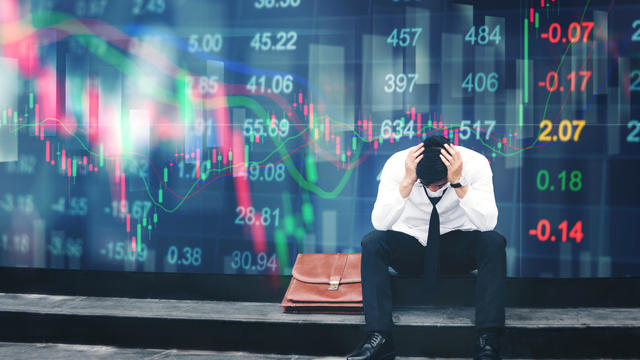 Tired or stressed businessman sitting on the walkway in panic digital stock market financial background 