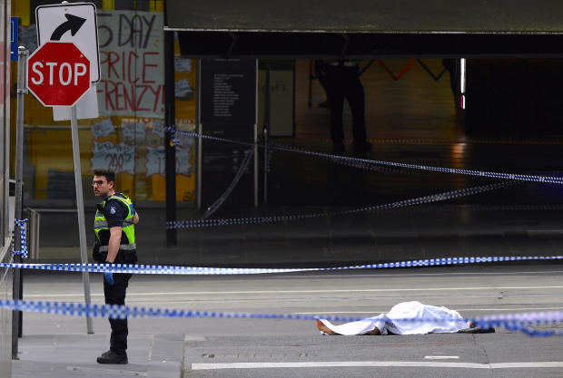 A policeman stands near a body covered with a sheet near the Bourke Street mall in central Melbourne 